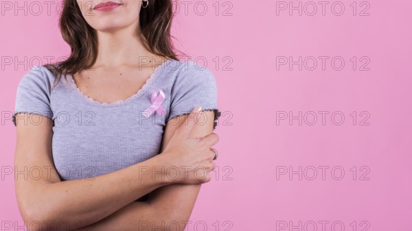 A pink badge ribbon on a woman's chest supporting breast cancer cause