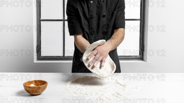 Front view man kneading pizza dough. High resolution photo