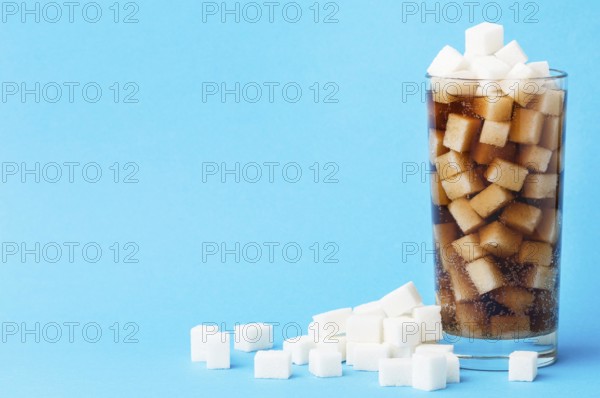 Front view glass soft drink with sugar cubes copy space. High resolution photo