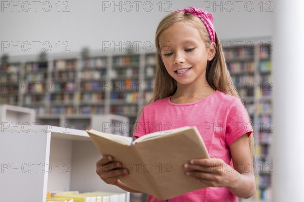 Little girl reading book library