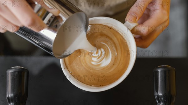 Top view male barista pouring milk coffee cups