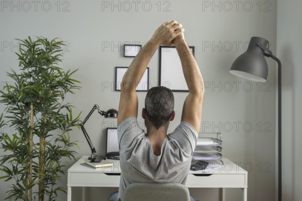Back view man desk stretching while working from home. Resolution and high quality beautiful photo