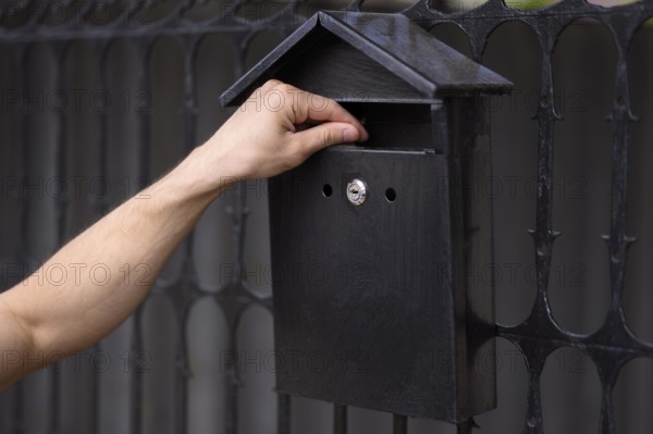 Close up hand touching mailbox