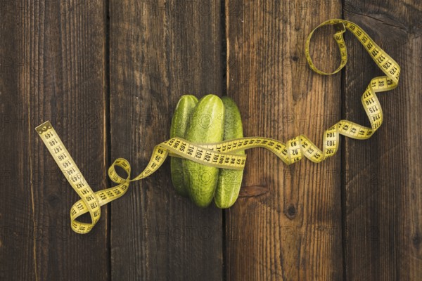 High angle view fresh cucumbers measuring tape wooden background. Resolution and high quality