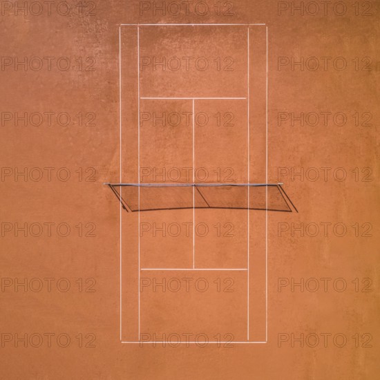 Aerial view of a single red clay tennis court without players