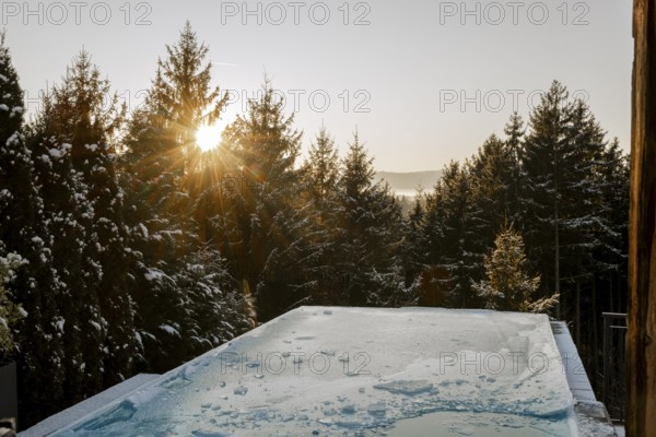 Frozen pool in winter at sunset