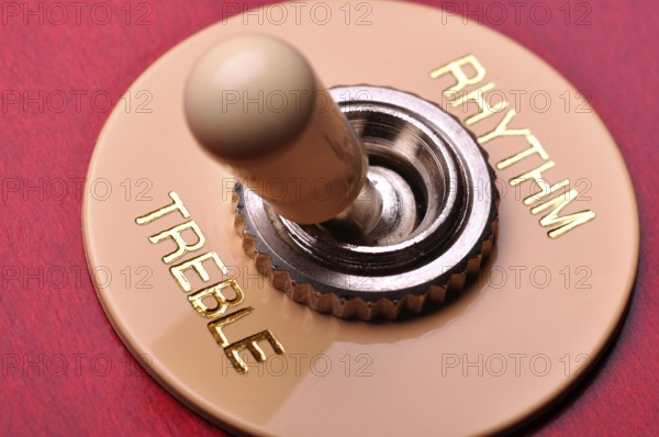 Closeup of a red electric guitar near the humbucker selector
