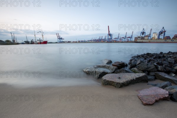 Elbe beach with container terminal and ships in the background in Hamburg