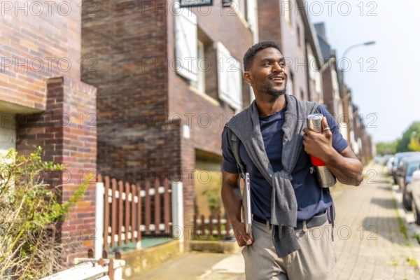 Confident young and handsome african man with casual clothes walking to go to work carrying a