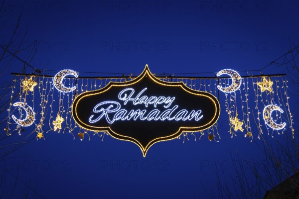 The illuminated lettering Happy Ramadan shines on the evening of 10 March 2024 as part of a light