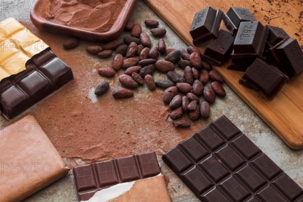 Overhead view chocolate bars with cocoa powder raw beans