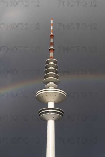 Weather symbol, Telemichel TV tower in front of a dramatic stormy sky with rainbow, Hamburg,