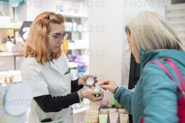 A pharmacist assists a client, showing her essential products. The image reflects the importance of