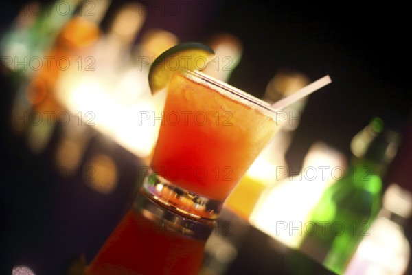 Tequila sunrise cocktail on night bar background