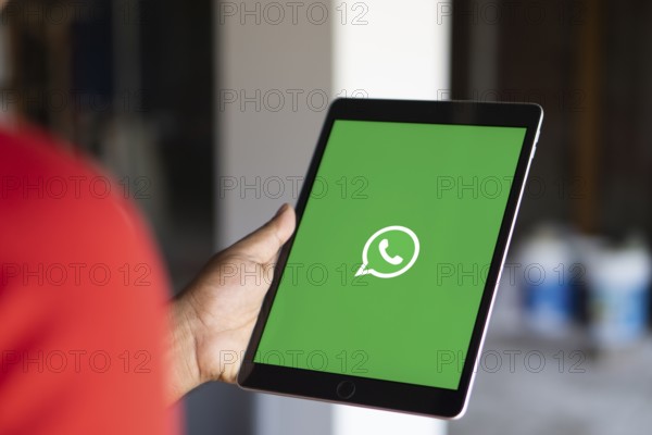 Man holding a cellphone with WhatsApp on the screen.Dhaka, Bangladesh- 09 September 2024.