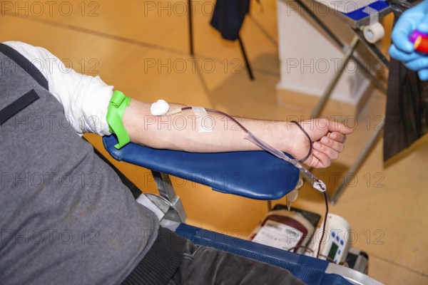Top view close-up of a man resting while donating blood in a center