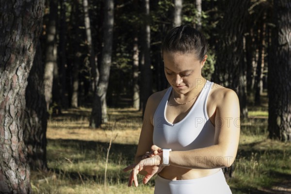 Young athletic woman looking at the stopwatch timer for her training session