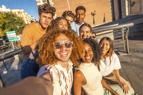 Man with curly hair and multi-ethnic friends taking selfie in the city