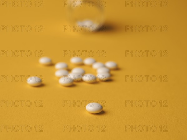 White pills on a yellow background, food supplements, vitamin pills, health care concept