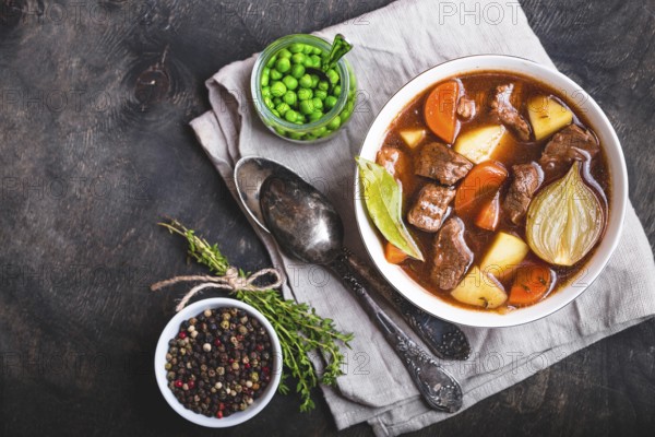 Meat stew with beef, potato, carrot, onion, spices. green peas. Slow cooked meat stew in bowl,