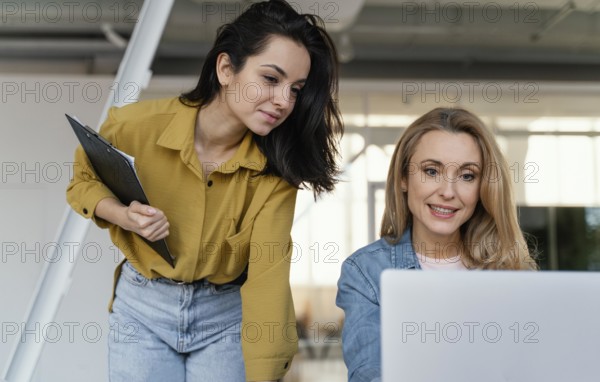 Women checking work project together