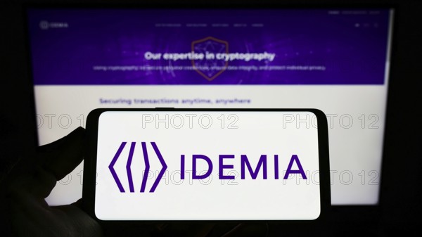 Stuttgart, Germany, 09-09-2022: Person holding smartphone with logo of technology company IDEMIA