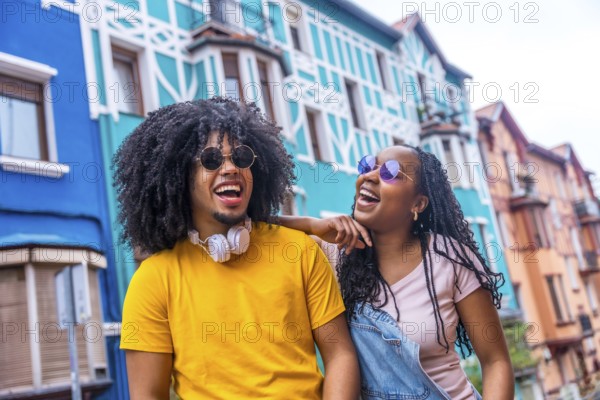Happy african cool friends with sunglasses and denim casual clothes laughing and chatting in a