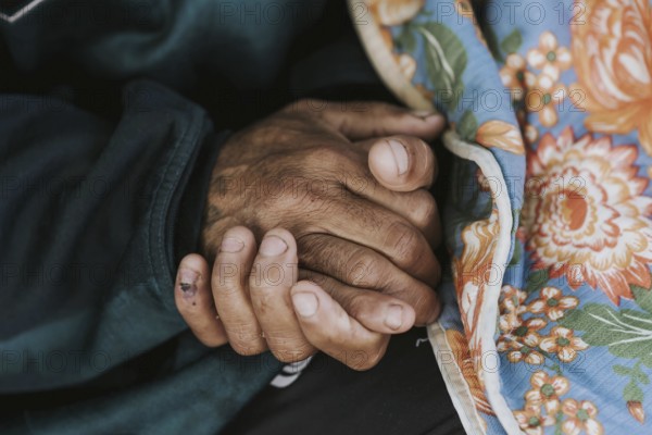 Homeless man holding his hands with blanket
