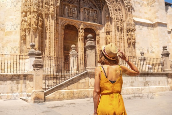 Young woman at the entrance door of the church of Santa María la Real in Aranda de Duero in the