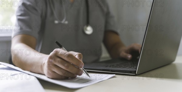 Side view doctor with stethoscope working laptop writing paper, Resolution and high quality
