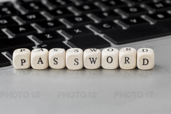 High angle defocused wooden cubes with password laptop