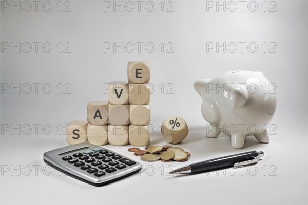 Home finance concept during inflation, wooden cubes with the word save and a percent sign, piggy
