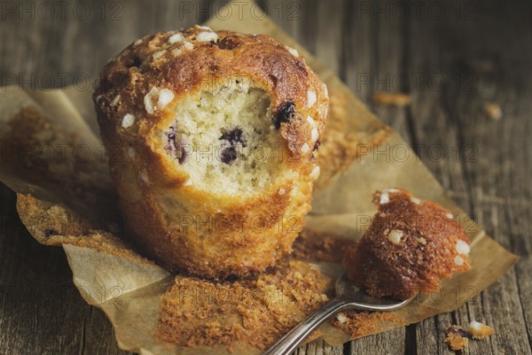 Blueberry muffin on baking paper with fork