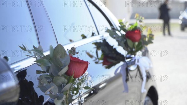 Wedding car decorated with flowers and ribbons, closeup