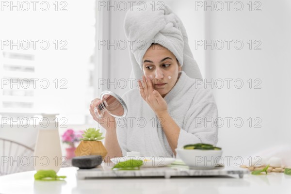 Front view woman applying face cream