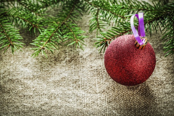 Pine tree branch Christmas bauble on sacking background