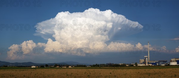 A storm cloud (Cumulonimbus) formed into an anvil over the Bavarian forest, Südzucker factory,