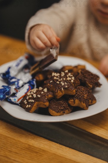 A child reaching for baked gingerbread cookies because of Christmas. Christmas vibe. Cookies with