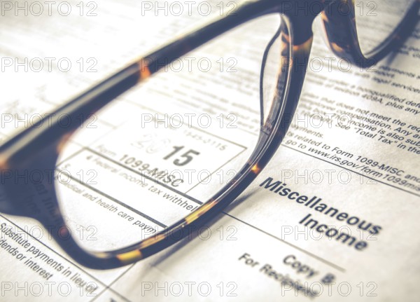 Retro Sepia Detail Of A Tax Form For 2015 Earnings For 2016 Tax Day With Glasses