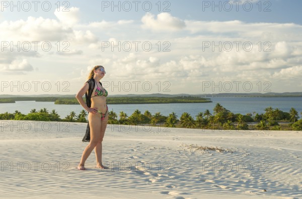 Young woman on the sand dunes of Mangue Seco beach located in Bahia