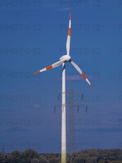 Wind turbine and high-voltage pylon with power lines at the Schacht Konrad wind farm, Salzgitter,