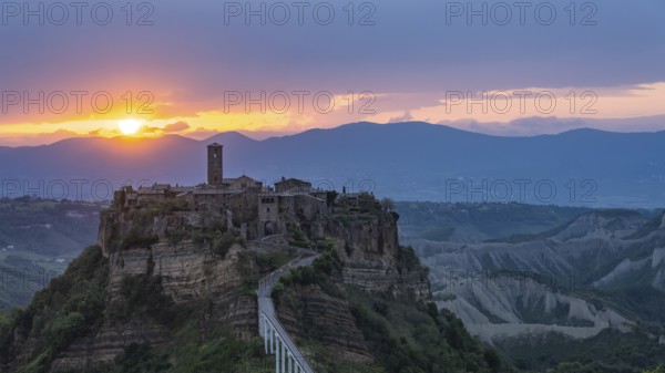 The mountain village of Civita di Bagnoregio in hilly landscape at sunrise, Civita di Bagnoregio,