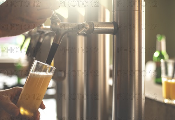 A landlord taps beer in a bar