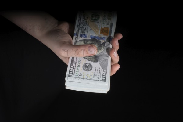Hand holding American dollar banknotes isolated on white background