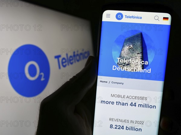 Stuttgart, Germany, 08-21-2023: Person holding cellphone with webpage of company Telefonica