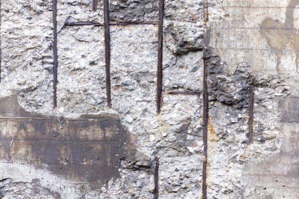 Textured concrete wall with exposed rebar and a rustic look