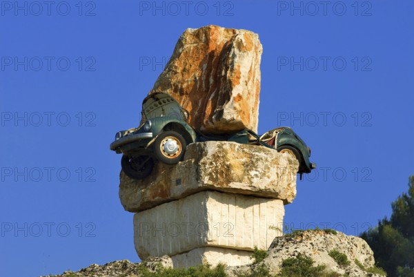 Art in south Italy, a green VW beetle totally crushed between huge boulders, Italy, Europe, Symbol,
