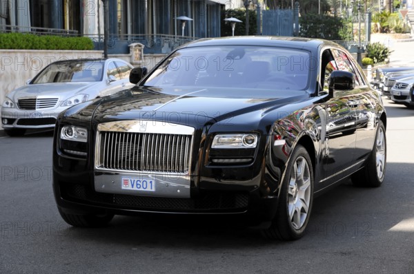 Rolls Royce Ghost at the casino, Monte Carlo, A black Rolls-Royce driving on the road in sunny