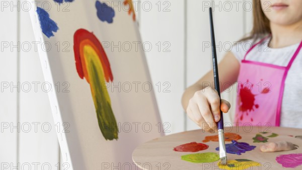 Close up girl painting with paint brush canvas