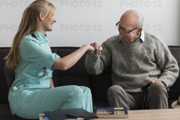 Old man nursing home fist bumping nurse